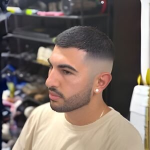 Men's fade haircut with textured top and clean sides.