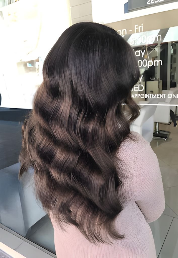 Long, wavy brunette hair styled professionally at a salon in Sydney CBD.